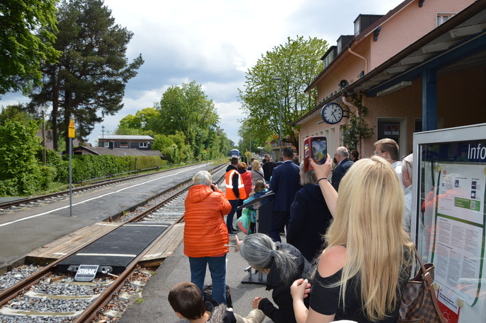 Eine Menschenmenge steht am Bahnsteig und wartet auf den Zug. 