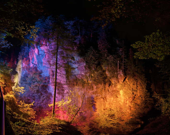 Das intermediale Festival „LICHTPFADE Kiefersfelden“ beleuchtet mit wunderbaren Farben verschiedene Objekte wie auf dem Foto einen Felsen. .