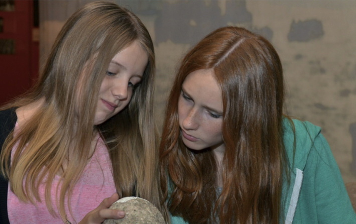 Zwei Mädchen mit Steinkugel im Küstenmuseum