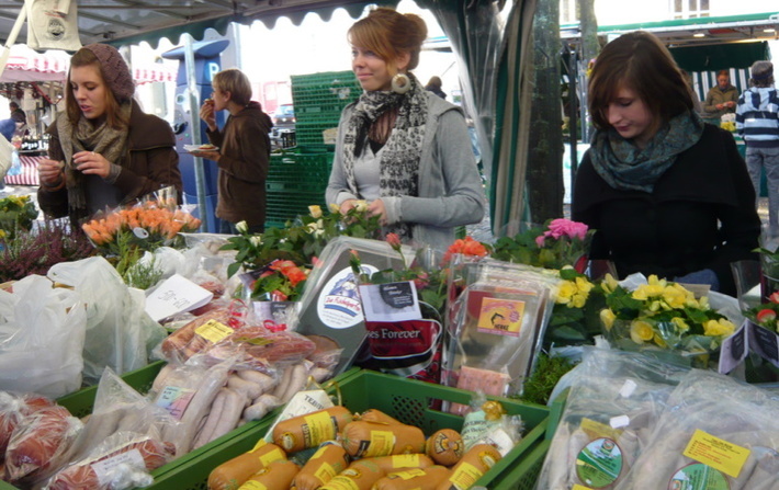 Frauen am Blumen- und Fleischstand auf dem Wochenmarkt