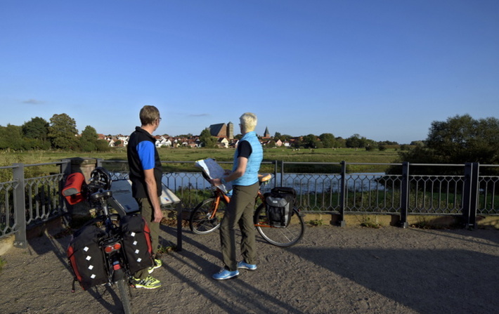 Radfahrer informieren sich mit Karte an der Aller