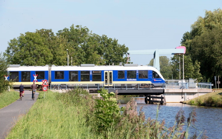 Museumsdorf Cloppenburg, Zug fährt über Kanalbrücke, Fahrradfahrer warten