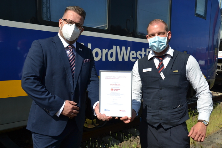 Dylan Bevers bekommt die Auszeichnung für den Landessieg von Robert Palm, Regionalleiter der Regio-S-Bahn Bremen/Niedersachsen und des Weser-Ems-Netzes, überreicht.