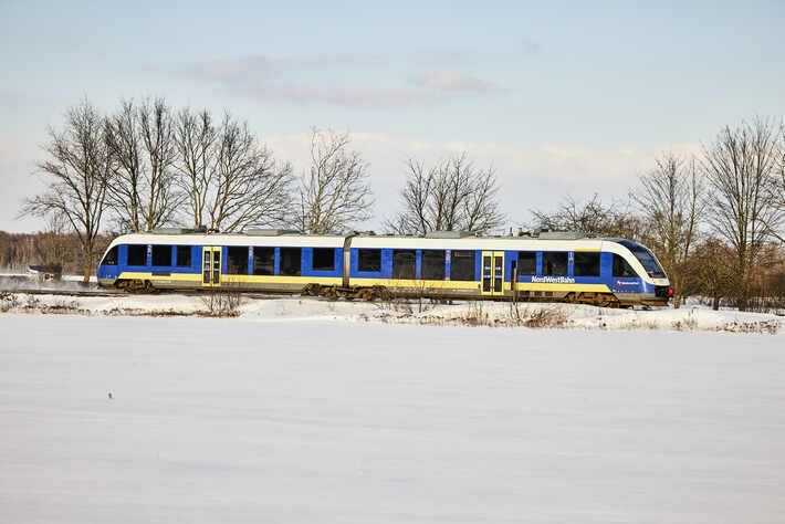 Zug der NordWestBahn fährt durch Schneelandschaft in Ostwestfalen-Lippe