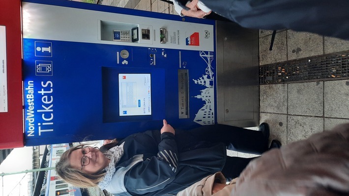 Birgit Schigiel, Leiterin Kundenbetreuer:innen im Netz Weser-Ems erklärt den Interessierten die Funktionen der Fahrkartenautomaten